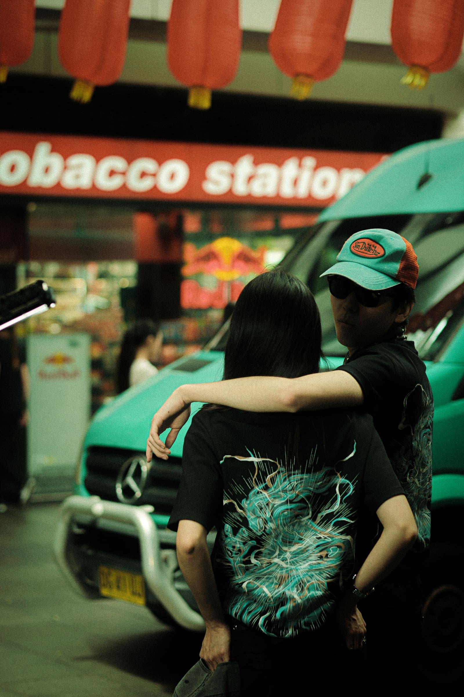 The back print against the teal van and a tobacconist's sign