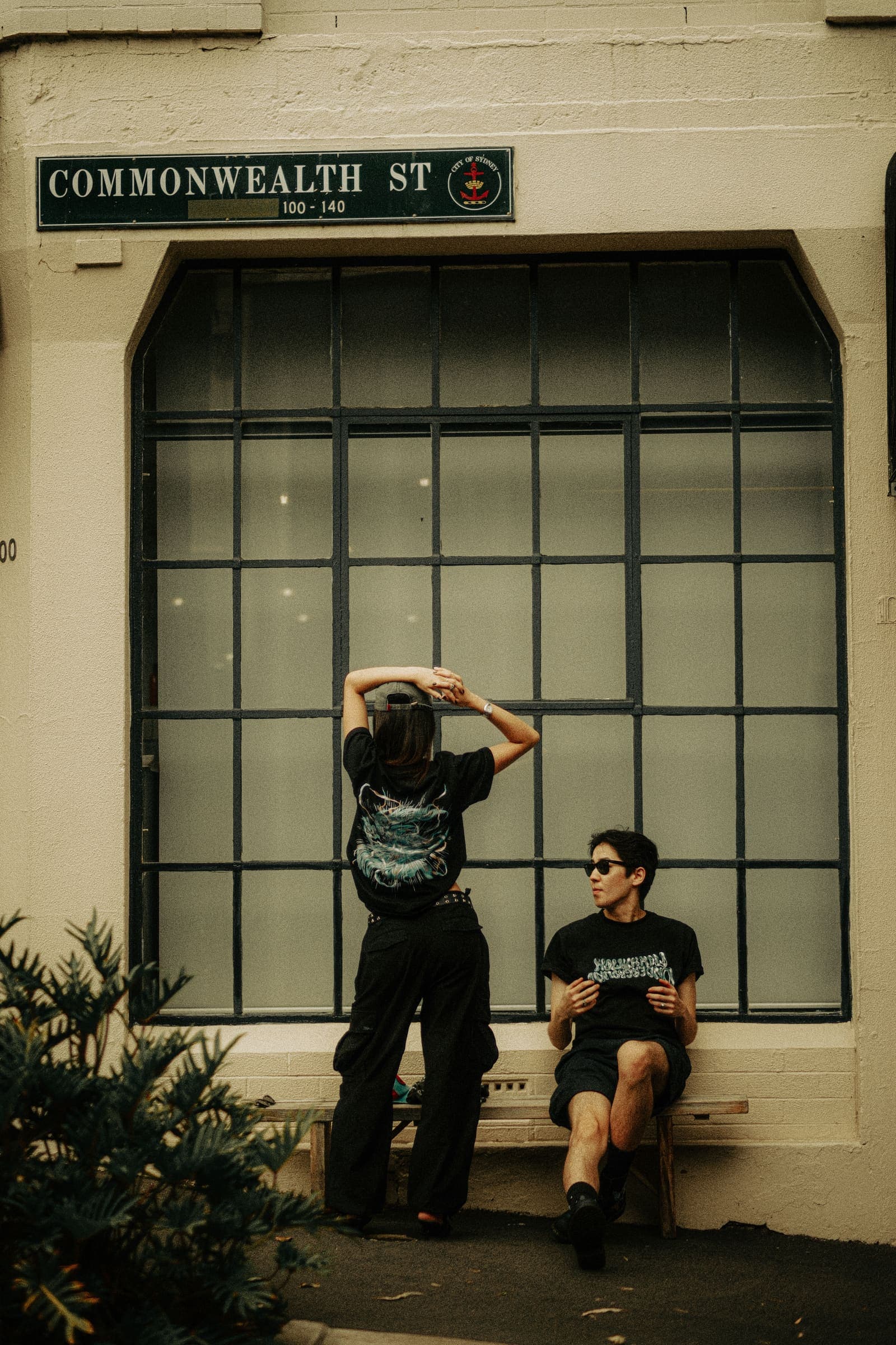 Two models at a window on Commonwealth Street, one showing the back print and one the front